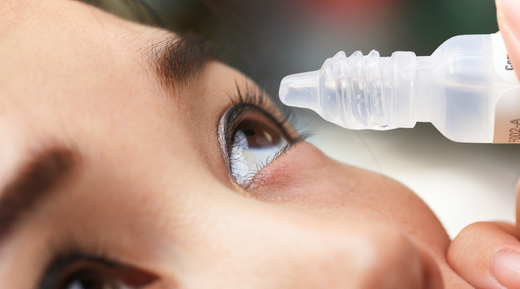 Close up of woman putting eye drops in eyes