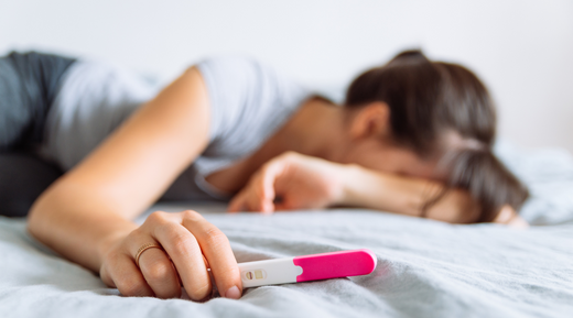 Sad woman with a negative pregnancy test.